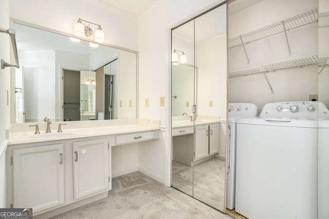 bathroom featuring vanity, washer and clothes dryer, and ornamental molding