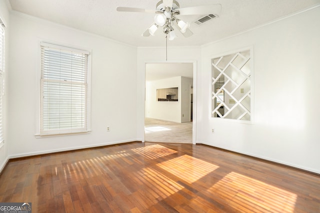 spare room featuring hardwood / wood-style flooring, ceiling fan, crown molding, and a textured ceiling