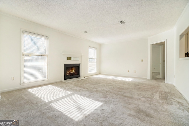 unfurnished living room with crown molding, light colored carpet, and a textured ceiling