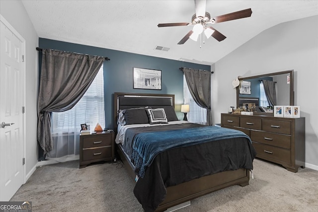 carpeted bedroom with ceiling fan and vaulted ceiling