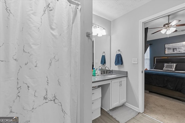 bathroom featuring vanity, a textured ceiling, ceiling fan, hardwood / wood-style flooring, and curtained shower