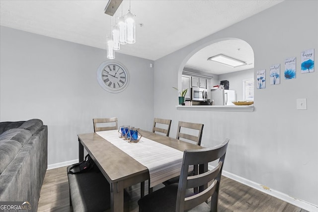 dining area featuring dark wood-type flooring