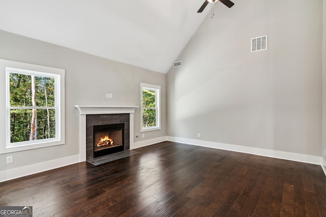 unfurnished living room featuring a fireplace, high vaulted ceiling, ceiling fan, and dark wood-type flooring