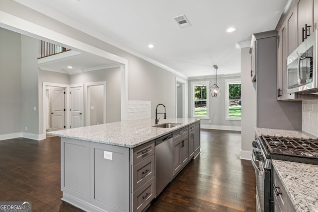 kitchen featuring light stone countertops, hanging light fixtures, dark hardwood / wood-style flooring, appliances with stainless steel finishes, and ornamental molding