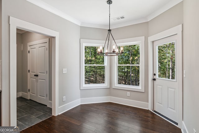 unfurnished dining area featuring a chandelier, dark hardwood / wood-style flooring, and crown molding