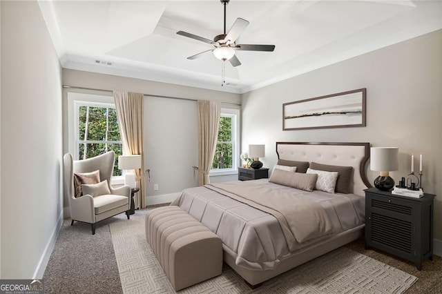 bedroom featuring ceiling fan, a raised ceiling, and light carpet