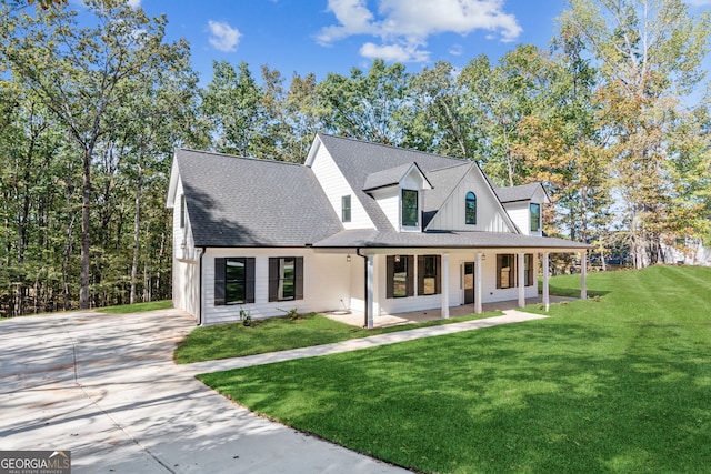 view of front of house with a porch, a garage, and a front lawn