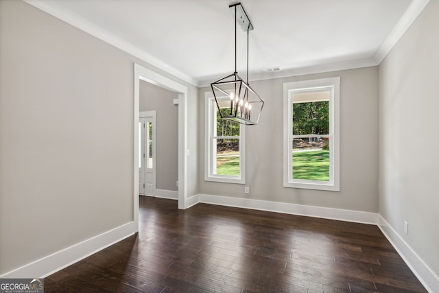 unfurnished dining area featuring dark hardwood / wood-style floors, ornamental molding, and an inviting chandelier