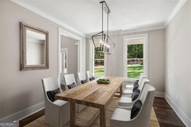 dining room featuring ornamental molding, dark wood-type flooring, and a notable chandelier