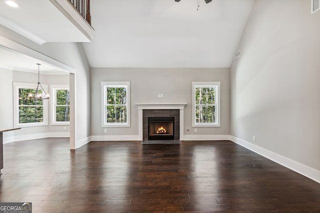 unfurnished living room with a fireplace, dark wood-type flooring, and a healthy amount of sunlight