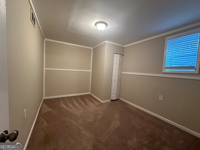 unfurnished bedroom with carpet flooring, crown molding, and a closet