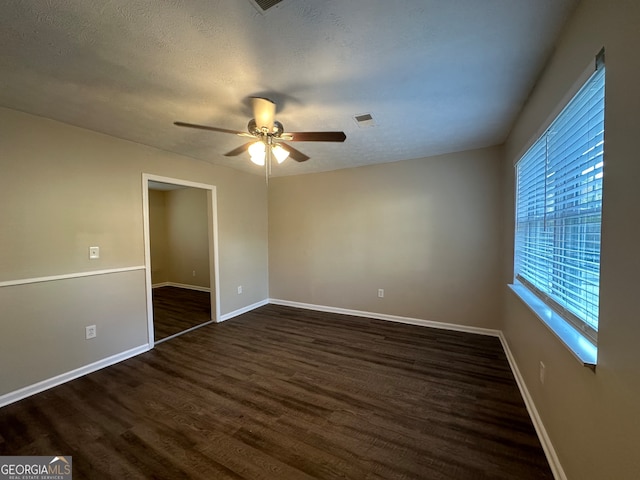 spare room featuring ceiling fan, dark hardwood / wood-style flooring, and a textured ceiling