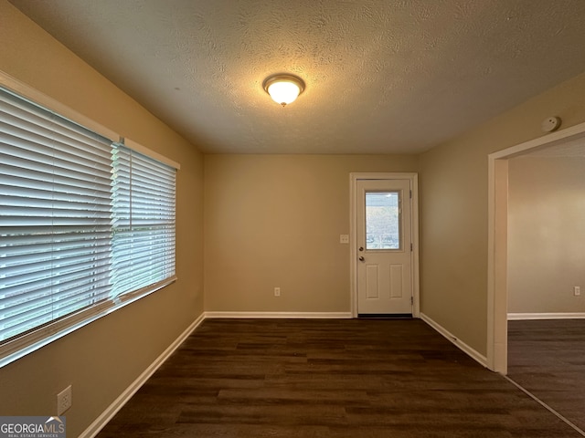 foyer featuring dark hardwood / wood-style flooring and a textured ceiling