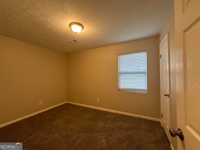 carpeted spare room featuring a textured ceiling