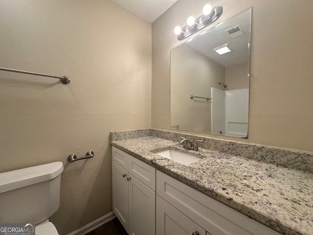 bathroom with walk in shower, vanity, and toilet