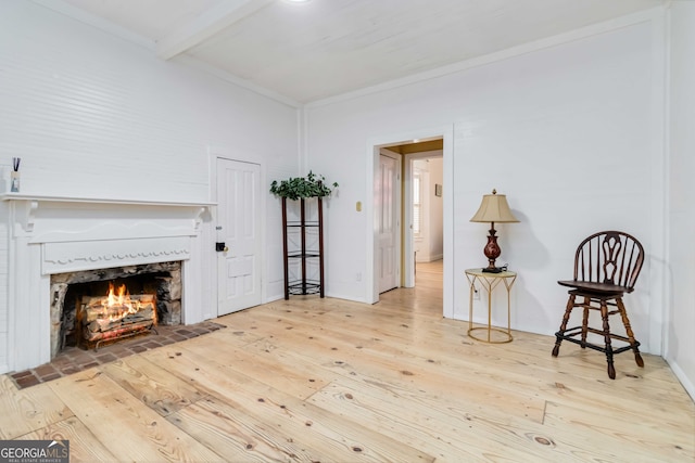 living area featuring beam ceiling and light wood-type flooring