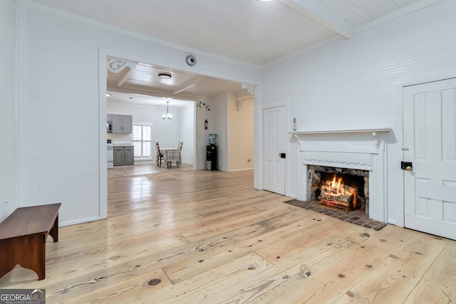 living room with beam ceiling, crown molding, and light hardwood / wood-style flooring