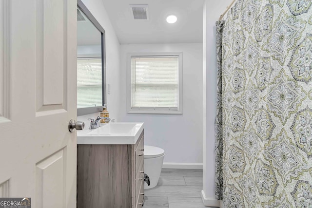 bathroom with vanity, wood-type flooring, and toilet