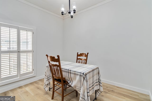 dining room with a chandelier, light hardwood / wood-style floors, and crown molding