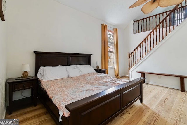 bedroom featuring ceiling fan, lofted ceiling, and light hardwood / wood-style flooring