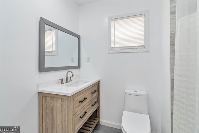 bathroom with wood-type flooring, vanity, and toilet