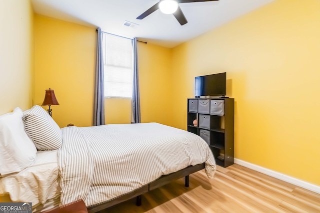 bedroom with hardwood / wood-style floors and ceiling fan