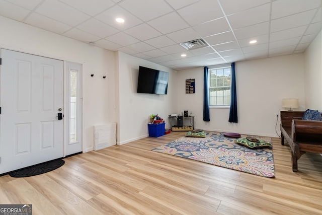 entrance foyer with wood-type flooring and a drop ceiling