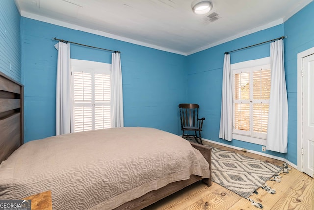 bedroom featuring wood-type flooring and ornamental molding