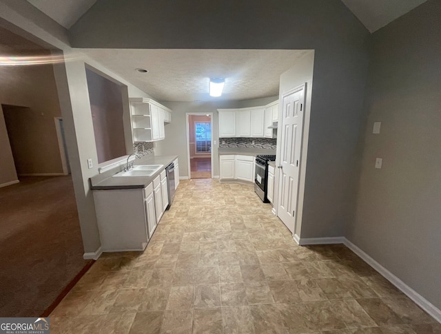 kitchen featuring white cabinetry, sink, stainless steel appliances, tasteful backsplash, and lofted ceiling