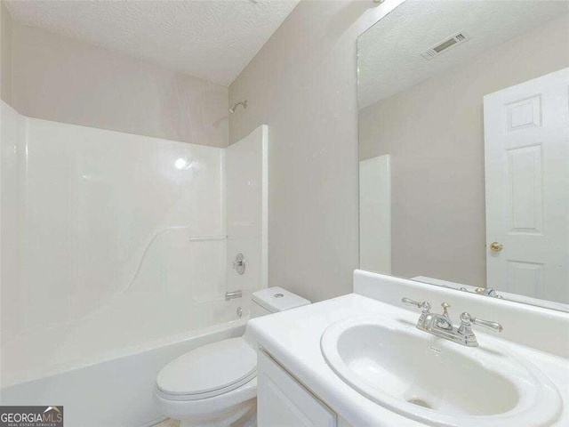 full bathroom with vanity, bathtub / shower combination, a textured ceiling, and toilet