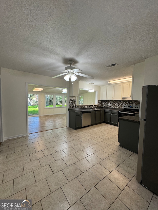 kitchen with ceiling fan, sink, stainless steel appliances, backsplash, and a textured ceiling