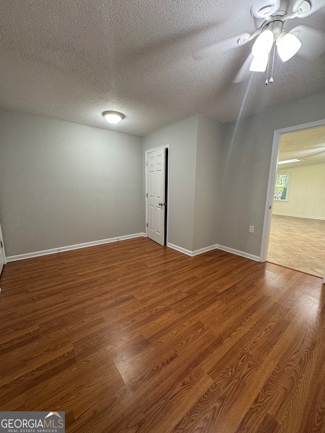 spare room featuring wood-type flooring, a textured ceiling, and ceiling fan