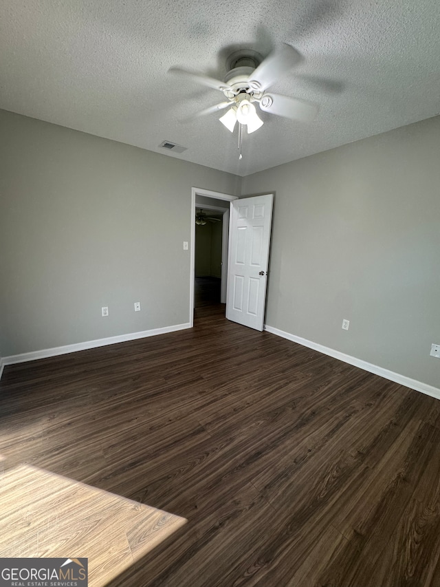 unfurnished bedroom with a textured ceiling, dark hardwood / wood-style flooring, and ceiling fan