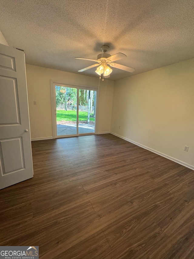 spare room with ceiling fan, dark wood-type flooring, and a textured ceiling