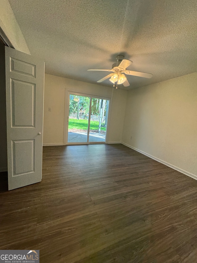 unfurnished room featuring dark hardwood / wood-style floors, ceiling fan, and a textured ceiling