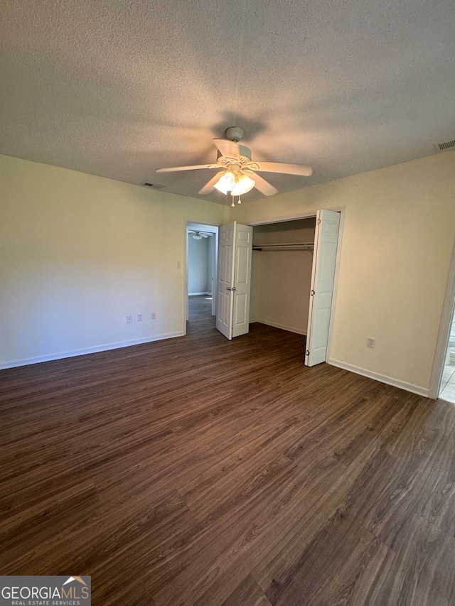 unfurnished bedroom featuring a textured ceiling, ceiling fan, and dark hardwood / wood-style floors