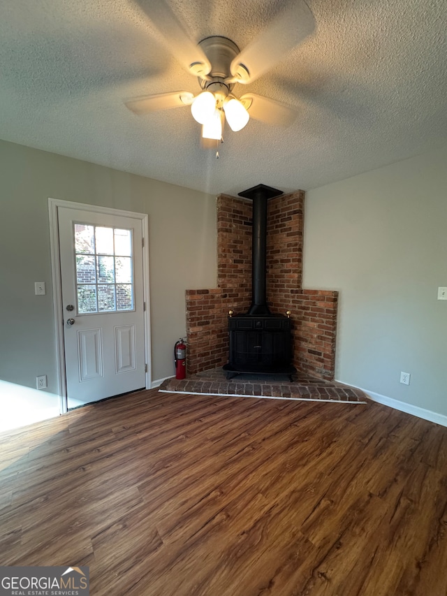 unfurnished living room featuring ceiling fan, a textured ceiling, and dark wood-type flooring