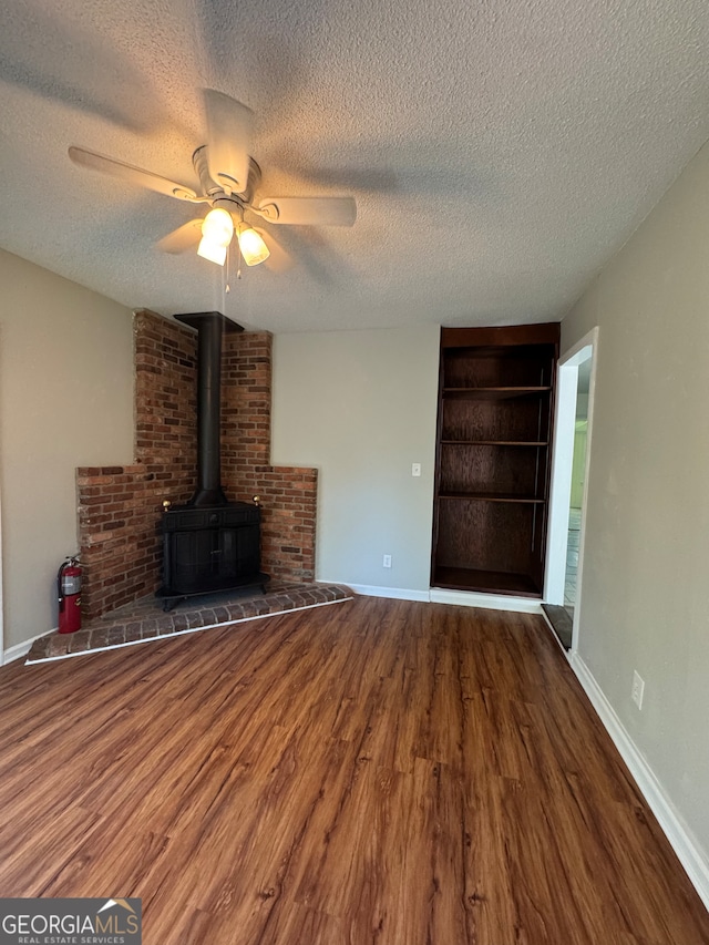 unfurnished living room with ceiling fan, dark wood-type flooring, and a textured ceiling