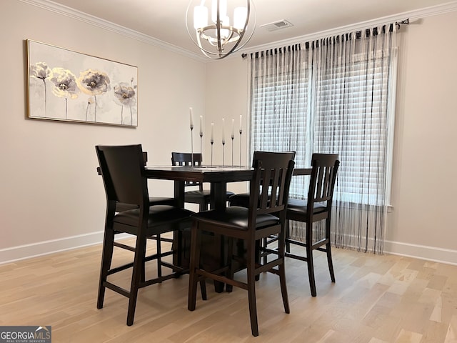 dining area featuring light wood-type flooring, an inviting chandelier, and ornamental molding