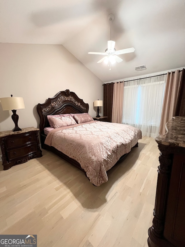 bedroom featuring ceiling fan, light hardwood / wood-style floors, and vaulted ceiling