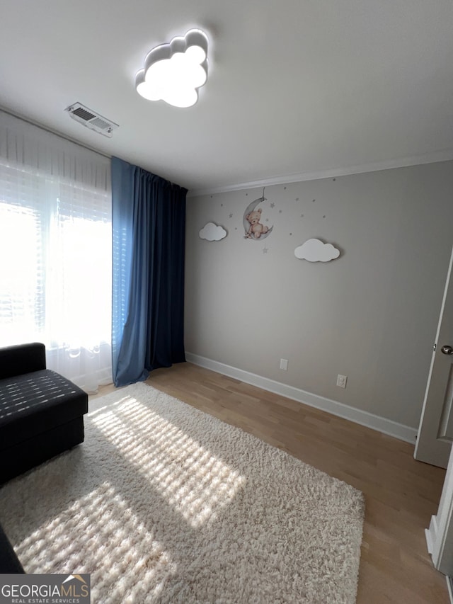 interior space featuring crown molding and light wood-type flooring