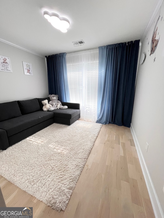 living room with wood-type flooring and ornamental molding