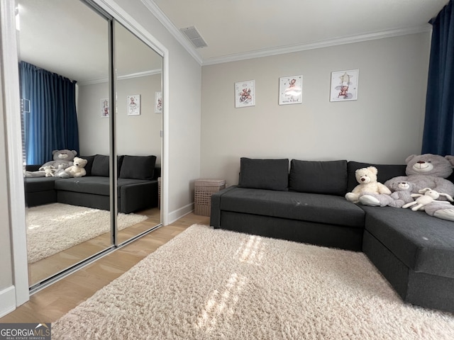 living room featuring light wood-type flooring and crown molding