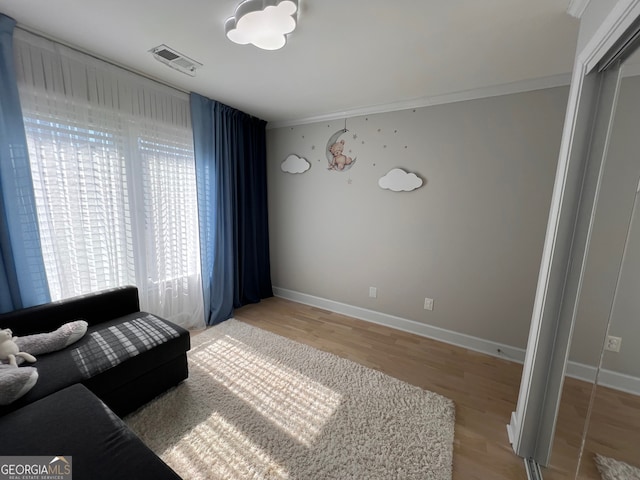 living room featuring crown molding and hardwood / wood-style flooring