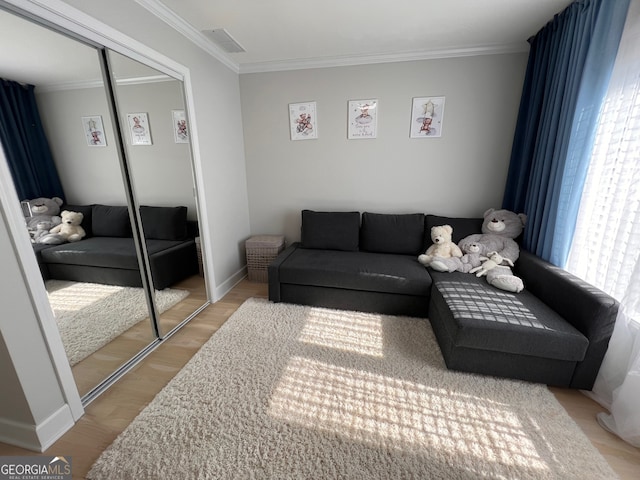 living room featuring light hardwood / wood-style floors and crown molding