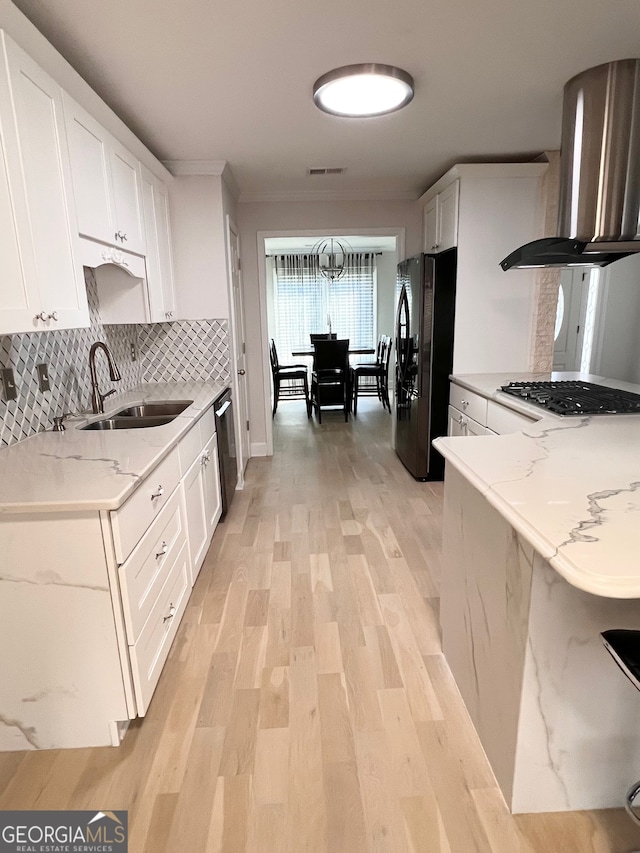 kitchen featuring light stone countertops, appliances with stainless steel finishes, sink, white cabinets, and range hood