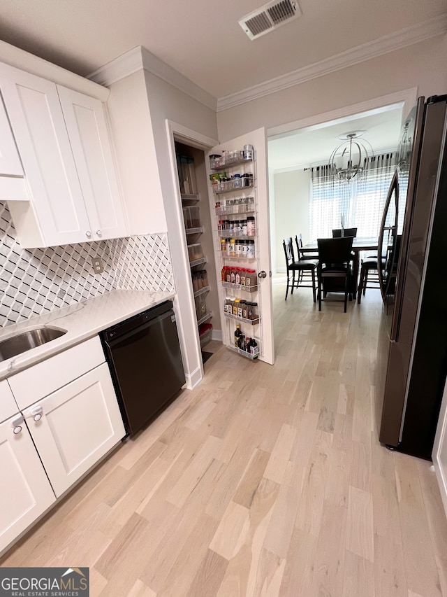 kitchen with tasteful backsplash, white cabinets, dishwasher, and refrigerator