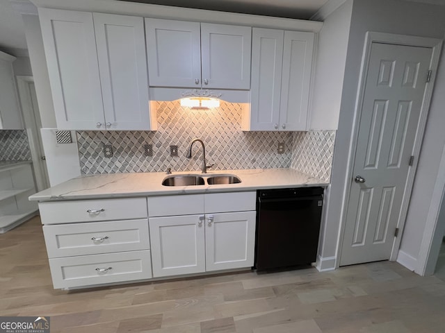 kitchen featuring black dishwasher, white cabinetry, and sink