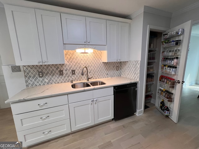 kitchen with ornamental molding, sink, light hardwood / wood-style flooring, white cabinets, and black dishwasher