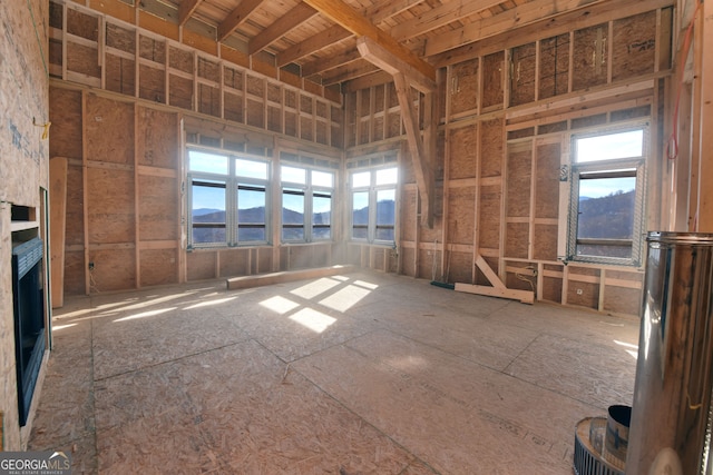 miscellaneous room with a wealth of natural light, a mountain view, and a high ceiling